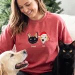 Red custom pet Christmas sweatshirt with an embroidered black cat named Scuba and a golden retriever named Tex
