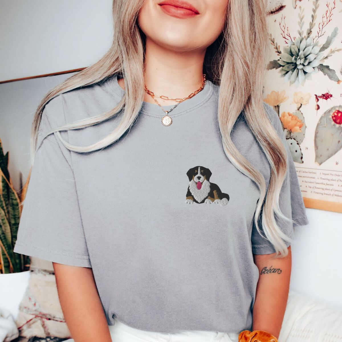 Cute Bernese Mountain Dog Shirt - Grey Woman in a Grey T-shirt embroidered with a small tricolor Bernese mountain dog puppy lying down on the left chest