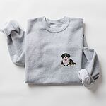Sport Grey crewneck sweatshirt laid flat on white, embroidered with a small Berner puppy lying down on the left chest
