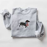 Sport Grey crewneck sweatshirt laid flat with rolled sleeves, a dachshund silhouette with an American flag stitched in the center
