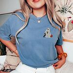 Woman in a Blue Jean T-shirt embroidered on the left chest with a ghost sipping iced coffee, a black and tan dachshund and a jack-o'-lantern pail