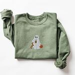 Military Green crewneck sweatshirt laid flat on white, embroidered with a ghost sipping iced coffee, a red dachshund standing up at her side and a jack-o'-lantern pail