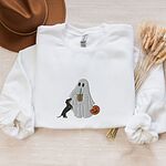 White crewneck sweatshirt laid flat with a brown hat and wheat stems, embroidered with a ghost sipping iced coffee, a black and tan dachshund standing up at her side and a jack-o'-lantern pail