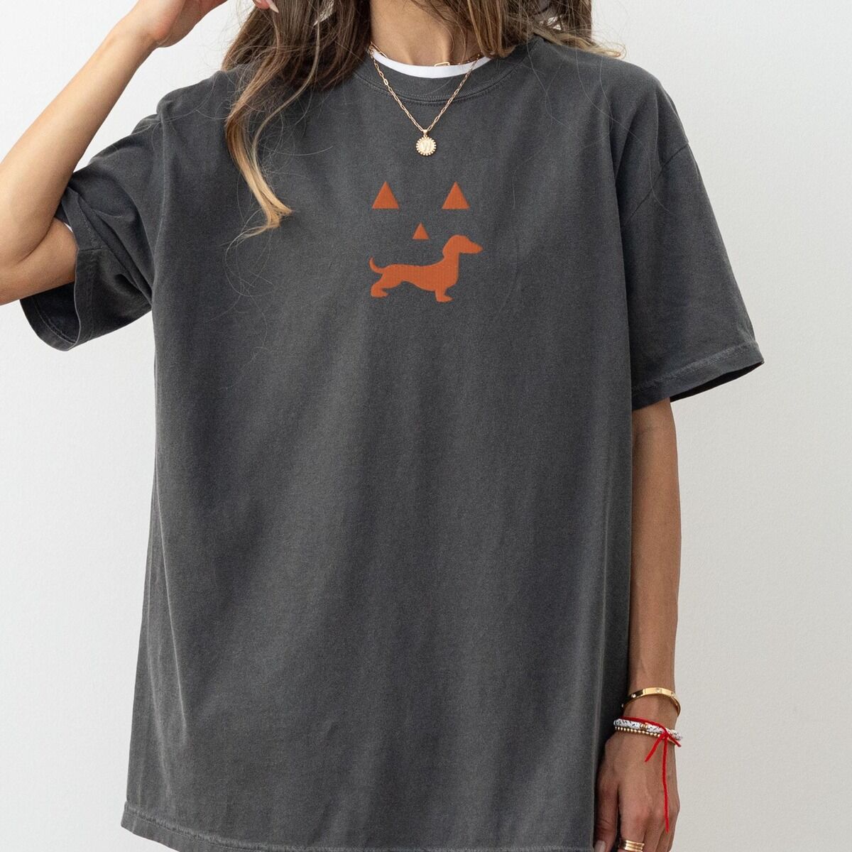 Dachshund Jack-o'-Lantern Shirt – Pepper Woman in a Pepper T-shirt embroidered across the chest with an orange jack-o'-lantern face whose grin is a dachshund silhouette
