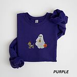 Purple crewneck sweatshirt laid flat on white, embroidered with a red dachshund in a skeleton costume and witch hat on a leash held by a ghost sipping iced coffee