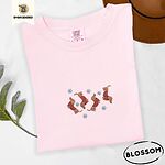 Blossom Comfort Colors T-shirt embroidered with four red dachshunds in red Fair Isle sweaters tumbling among light blue snowflakes