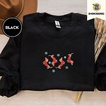 Black crewneck sweatshirt with a brown felt hat and dried bunny tail grass, embroidered with four red dachshunds in red Fair Isle sweaters tumbling among light blue snowflakes