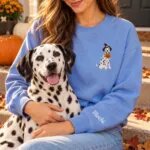 Dalmatian mom wearing the Heather Deep Royal Halloween sweatshirt with her Dalmatian on a fall porch