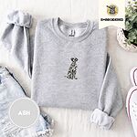 Ash crewneck sweatshirt folded with denim shorts, white sneakers and a potted plant, embroidered with a sitting Dalmatian in white with black spots and a black outline
