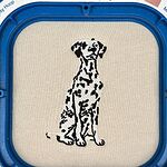 Sand sweatshirt held in a blue magnetic embroidery hoop with a freshly stitched sitting Dalmatian in white with black spots and a black outline