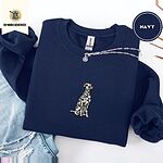 Navy crewneck sweatshirt folded with ripped jeans and a silver chain necklace, embroidered with a sitting Dalmatian in white with black spots and a black outline