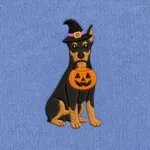 Close-up of the embroidered Doberman Pinscher in a witch hat with a jack-o'-lantern candy bucket