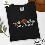 Black Comfort Colors T-shirt embroidered with a row of dog treats, a tennis ball, a chocolate Lab face, paw prints and a food bowl above the words DOG MOM