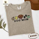Khaki Comfort Colors T-shirt embroidered with a row of dog treats, a tennis ball, a chocolate Lab face, paw prints and a food bowl above the words DOG MOM