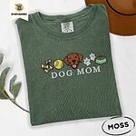 Moss Comfort Colors T-shirt embroidered with a row of dog treats, a tennis ball, a chocolate Lab face, paw prints and a food bowl above the words DOG MOM