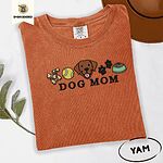 Yam Comfort Colors T-shirt embroidered with a row of dog treats, a tennis ball, a chocolate Lab face, paw prints and a food bowl above the words DOG MOM