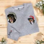 Grey sweatshirt with an embroidered dog portrait in a Santa hat on the chest and the name Rocky with a heart on the sleeve
