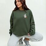Woman crouching in a Military Green crewneck sweatshirt embroidered on the left chest with a ghost sipping red wine, a black and tan dachshund and a jack-o'-lantern