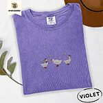 Violet Comfort Colors T-shirt embroidered with three white ducks in Santa hats and red rain boots under silver snowflakes