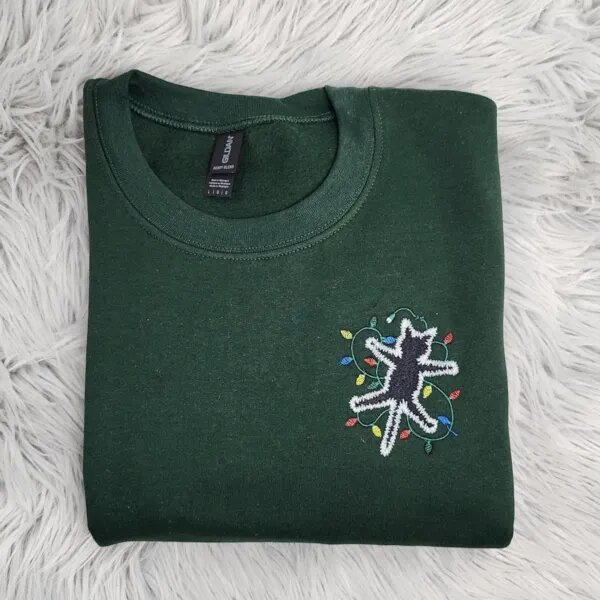 Electrocuted cat crewneck in Forest Green with the shocked black cat and colorful Christmas light bulbs on the left chest