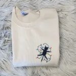 Electrocuted cat sweatshirt in Sand with a black cat tangled in Christmas lights embroidered on the left chest