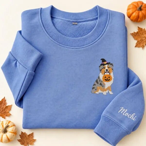 Embroidered Australian Shepherd Halloween sweatshirt in Heather Deep Royal with a witch-hat Australian Shepherd holding a pumpkin bucket on the left chest