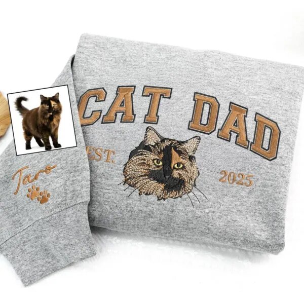 Sport grey sweatshirt with copper CAT DAD lettering, an embroidered tortoiseshell cat face, EST. 2025 and the name Taro with paw prints on the sleeve