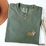 Moss Comfort Colors T-shirt embroidered with a cute cartoon corgi in golden tan and white trotting on the left chest