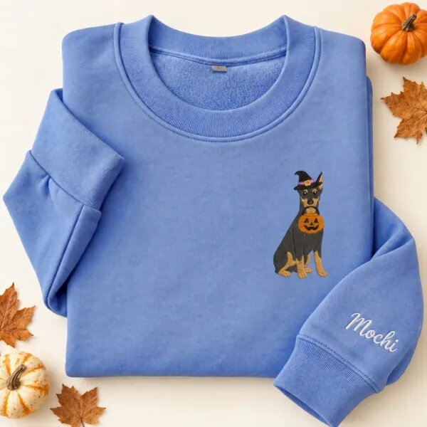 Embroidered Doberman Halloween sweatshirt in Heather Deep Royal with a witch-hat Doberman Pinscher holding a pumpkin bucket on the left chest