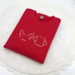 Red embroidered dog ears sweatshirt with white outline ears and the names Josie and Cooper
