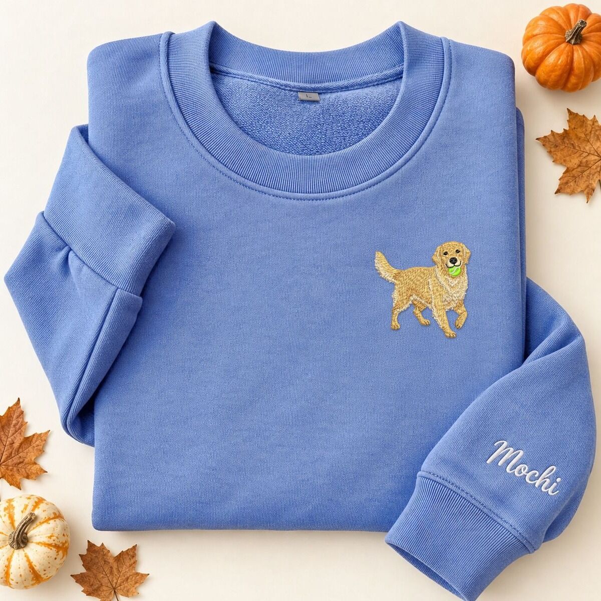 Embroidered Golden Retriever Sweatshirt – Tennis Ball and Sleeve Name Folded blue embroidered golden retriever sweatshirt with a mini golden carrying a green tennis ball on the left chest and the name Mochi in white script on the sleeve