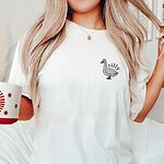 Woman holding a mug in a White T-shirt embroidered with a small white goose and the word silly