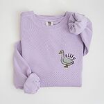 Orchid crewneck sweatshirt laid flat, embroidered with a little white goose with the word silly arched over its back on the left chest