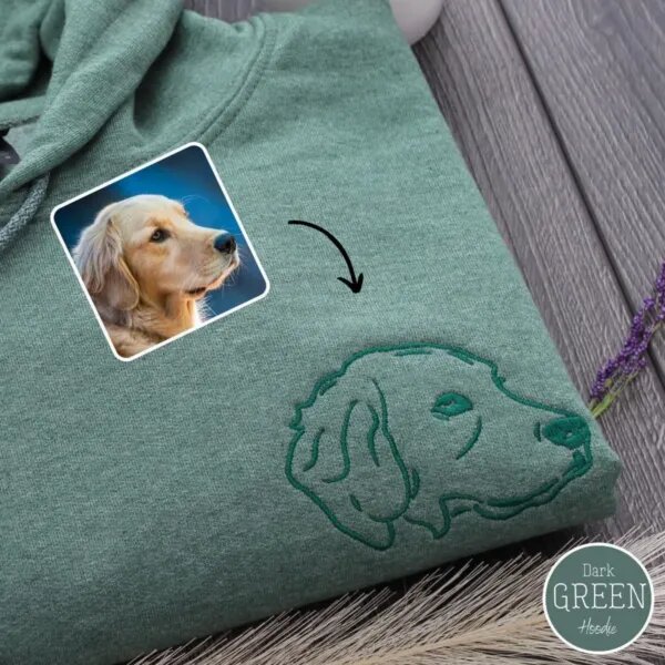 Green hoodie with a line art golden retriever head embroidered in dark green thread, next to the dog's photo