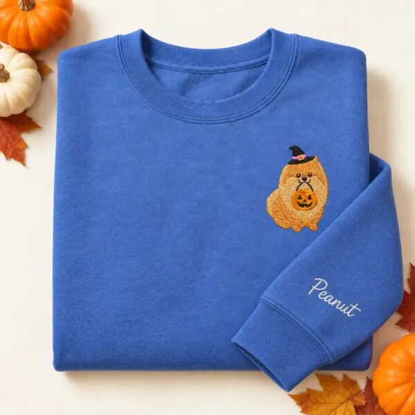 Embroidered Pomeranian Halloween sweatshirt in Heather Deep Royal with a witch-hat Pomeranian holding a pumpkin bucket on the left chest and the name Peanut on the left sleeve
