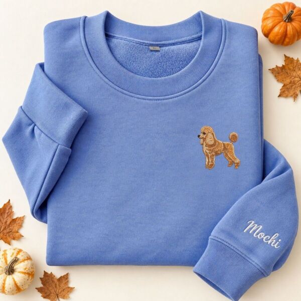 Folded Heather Deep Royal embroidered poodle sweatshirt with a mini apricot poodle on the left chest and the name Mochi in white script on the sleeve