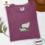 Berry Comfort Colors T-shirt embroidered with a woolly white ewe standing over her lamb resting on green grass