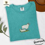 Seafoam Comfort Colors T-shirt embroidered with a woolly white ewe standing over her lamb resting on green grass