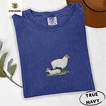 True Navy Comfort Colors T-shirt embroidered with a woolly white ewe standing over her lamb resting on green grass