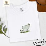 White Comfort Colors T-shirt embroidered with a woolly white ewe standing over her lamb resting on green grass