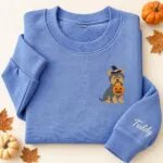 Embroidered Yorkie Halloween sweatshirt in Heather Deep Royal with a witch-hat Yorkshire Terrier holding a pumpkin bucket on the left chest