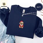 Navy crewneck sweatshirt folded with ripped jeans and a silver chain necklace, embroidered with a fawn English bulldog in a red Santa suit, black belt and Santa hat