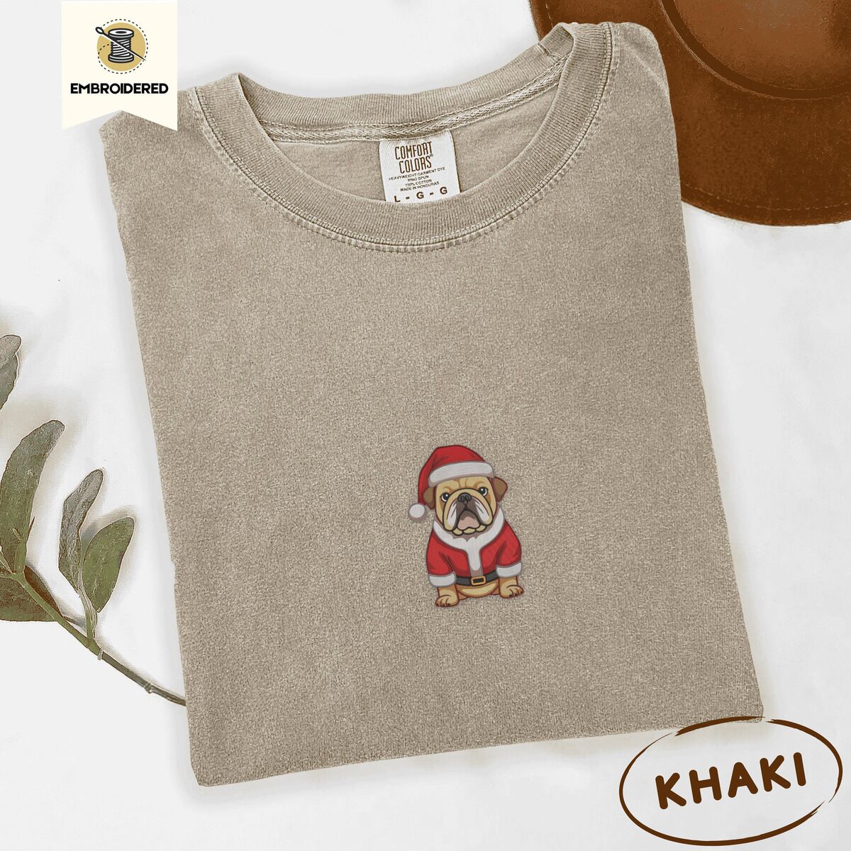 English Bulldog Santa Shirt – Khaki Khaki Comfort Colors T-shirt embroidered with a fawn English bulldog in a red Santa suit, black belt and Santa hat