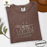 Espresso Comfort Colors T-shirt embroidered with a liver and white English pointer on point among cattails and grass, with an optional name stitched below