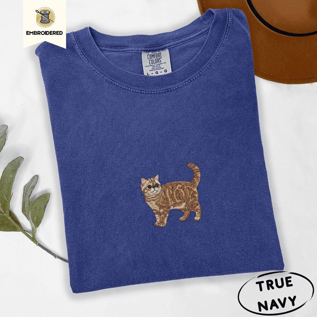 Exotic Shorthair Shirt – True Navy True Navy Comfort Colors T-shirt embroidered with an orange tabby Exotic Shorthair cat standing in profile with a flat face, round black eyes and a curled tail