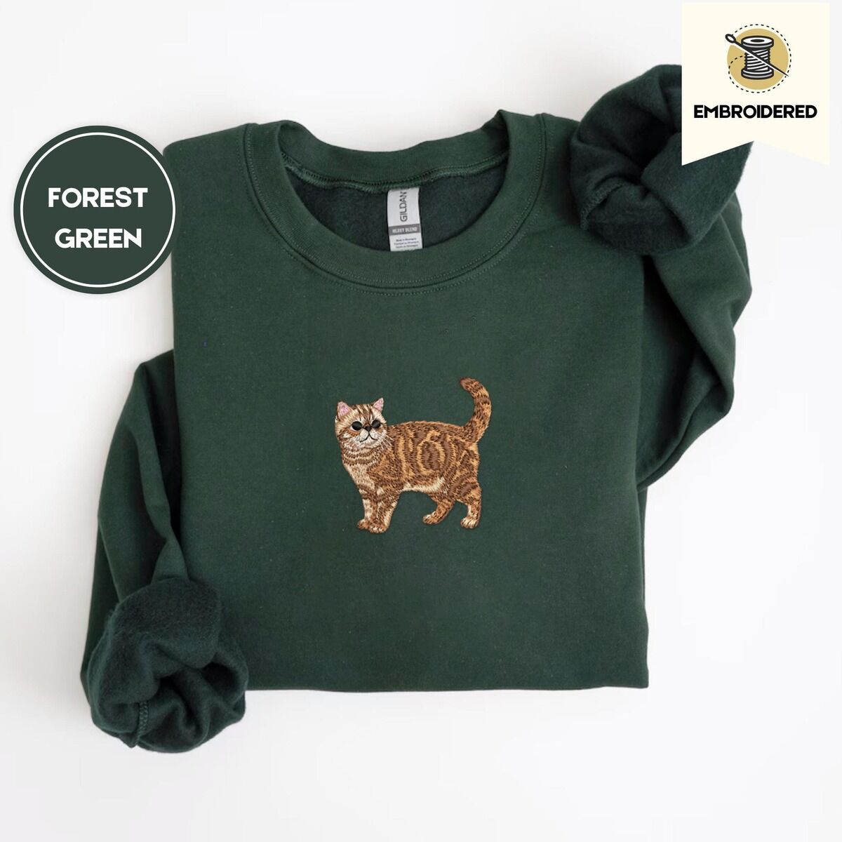 Exotic Shorthair Sweatshirt – Forest Green Forest Green Exotic Shorthair sweatshirt folded on a white background, with a mini embroidered orange tabby cat centered on the chest