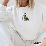 Woman sitting in a White crewneck sweatshirt embroidered with a golden retriever in a red Santa hat carrying colored lights