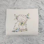 Floral Highland cow sweatshirt in Sand with a brown cow outline filled with yellow and blue wildflowers
