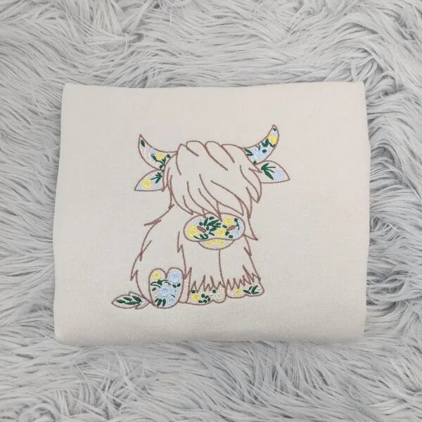 Floral Highland cow sweatshirt in Sand with a brown cow outline filled with yellow and blue wildflowers