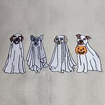 Close-up of the embroidery: four dogs in ghost sheets with brown, gray and golden ears, the last one holding an orange jack-o'-lantern bucket, stitched on a Sand sweatshirt